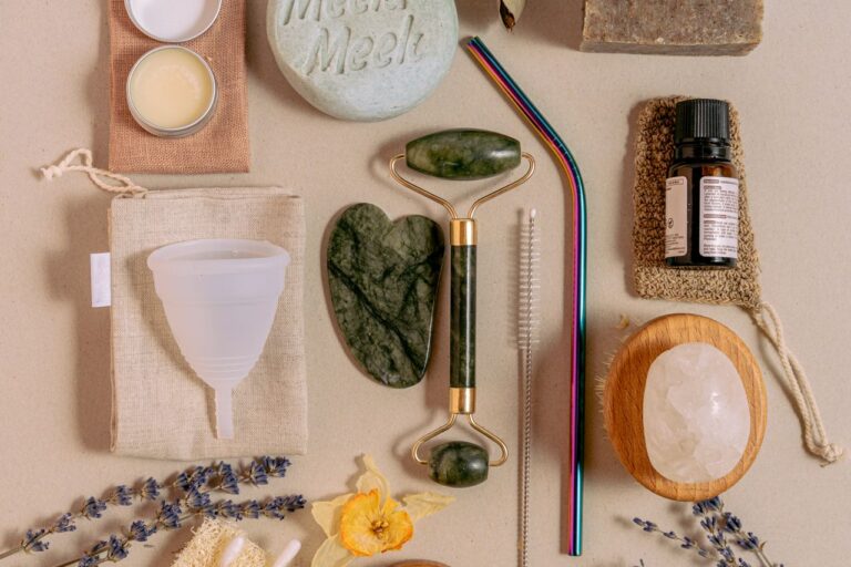 Flat lay of sustainable beauty products featuring jade roller, menstrual cup, and reusable straws.
